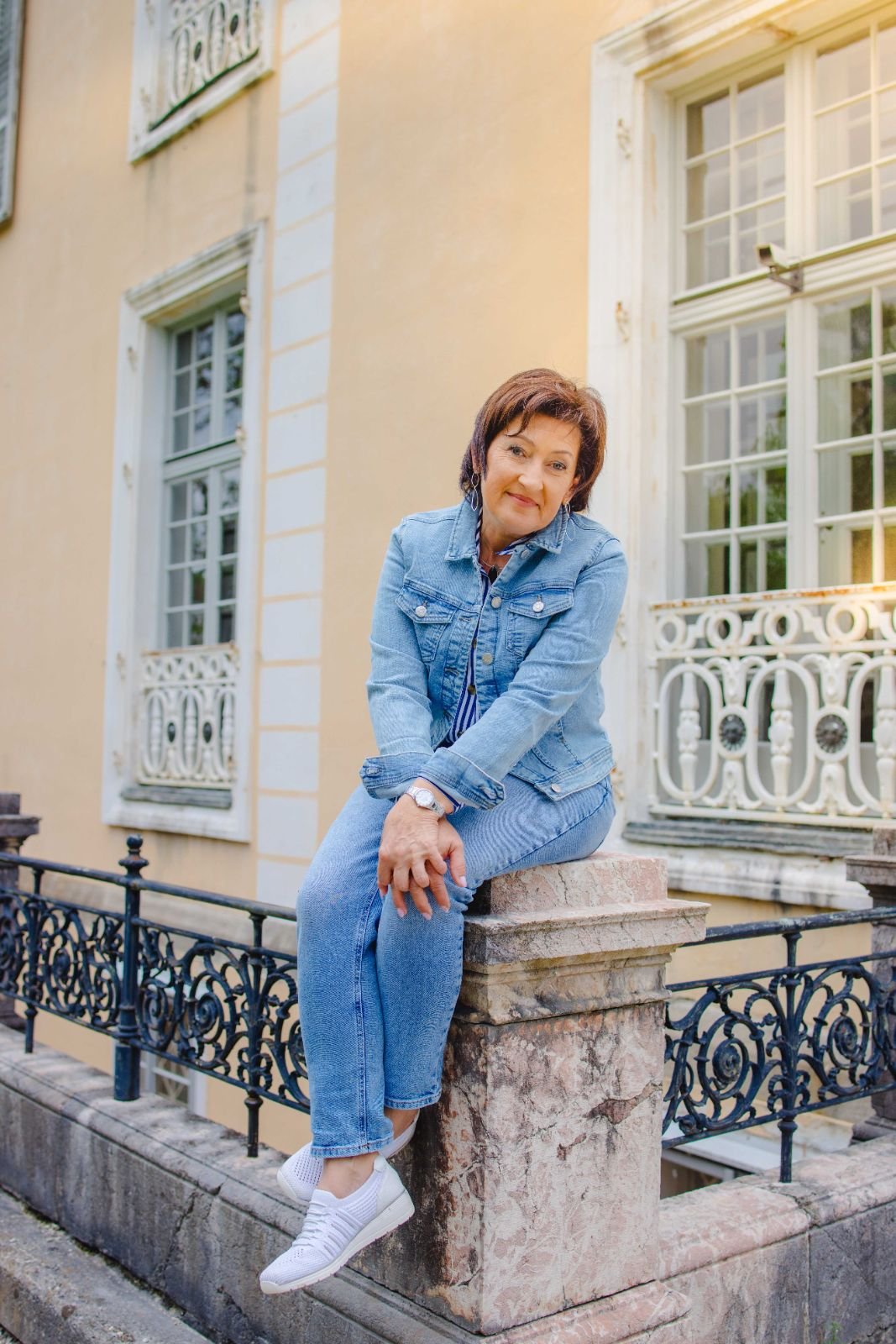 Gabriele Prentner sitzt entspannt auf einer Steinmauer